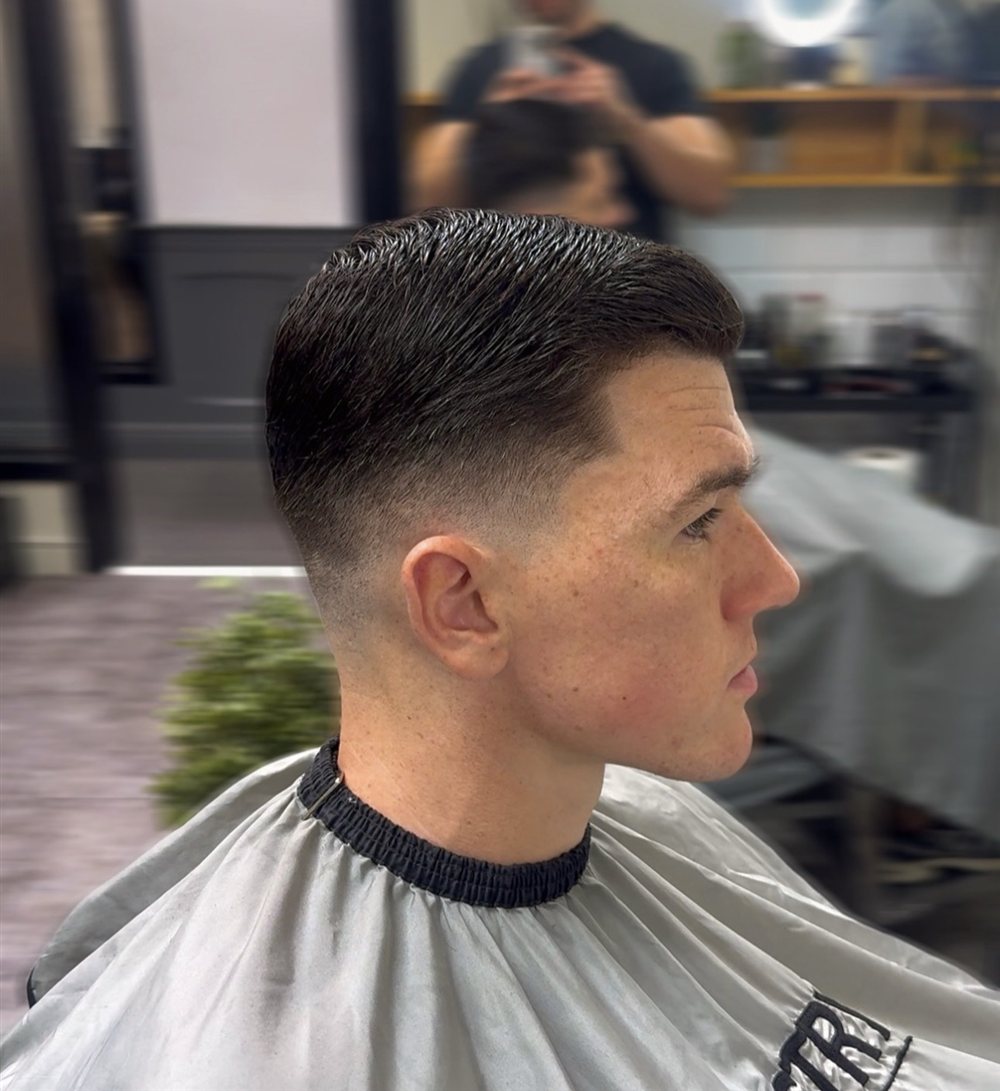 Side profile of a skin fade with a slicked-back textured top